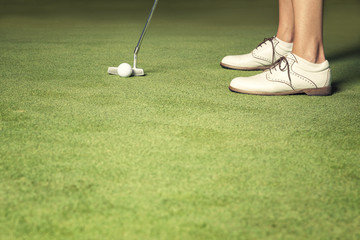 Close up of woman about to make a putt.