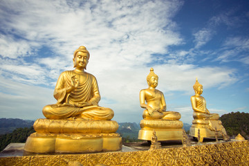 Three buddhas against the sky