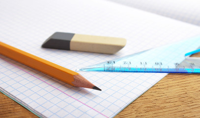 closeup of pencil notebook and eraser on wooden desk
