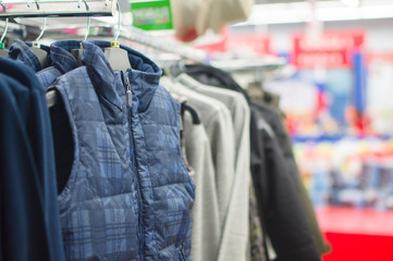 Obraz premium Vests and jackets on stands in supermarket