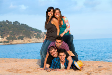 Friends making human pile on beach.
