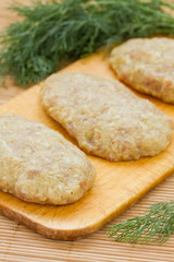 Raw meatballs with dill on breadboard