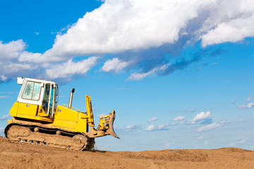 Bulldozer moves with raised blade on construction site
