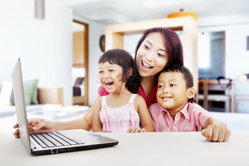 Fototapeta na wymiar Szczęśliwa rodzina z laptopem w domu 1