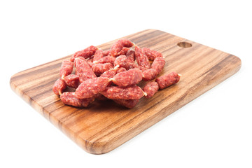 A heap of mini Salamis on wooden board