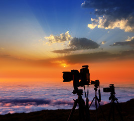 camera tripods photographer sunset sea of clouds