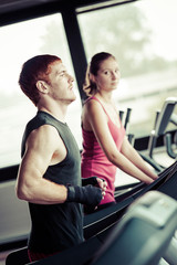 Running on treadmill in gym or fitness club - group of women and
