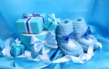 beautiful gifts and baby's bootees on blue silk