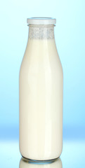 bottle of milk on blue background close-up