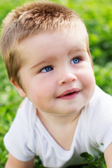 Happiness Baby boy sitting on the grass in field