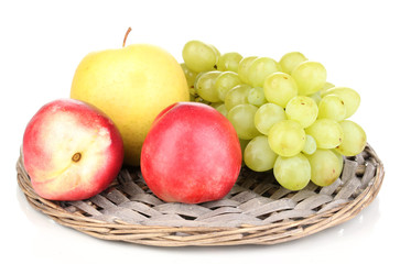 ripe sweet fruits and berries on wicker mat isolated on white