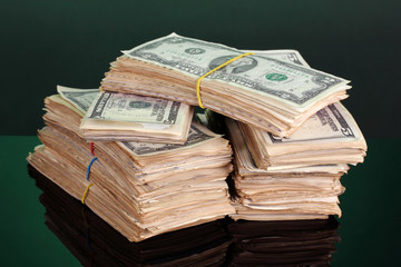Stacks of dollars on green background