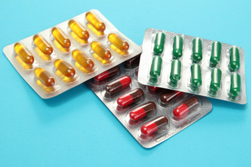 Capsules packed in blisters, on blue background