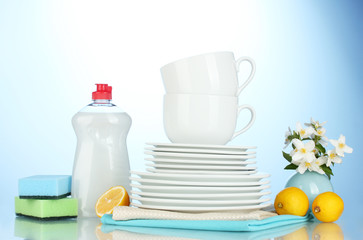 empty clean plates and cups with dishwashing liquid, sponges