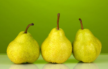 Ripe pears on bright green background