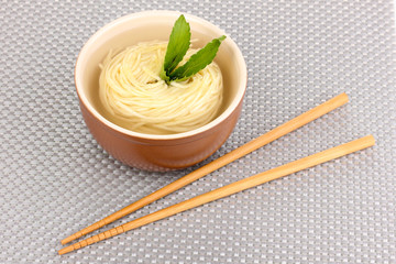 asian noodles in bowl on grey mat
