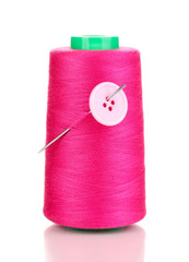 Pink bobbin with needle and buttons isolated on white