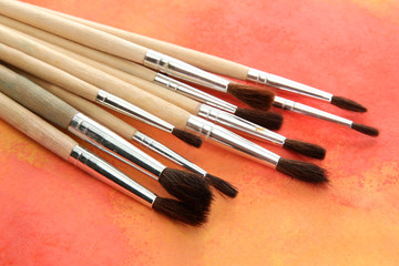 brushes on bright abstract gouache painted background