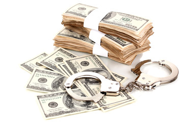 Handcuffs and packs of dollars isolated on white