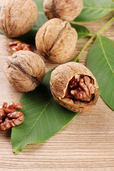 walnuts with green leaves, on wooden background