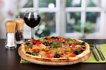 Delicious pizza with glass of red wine and spices