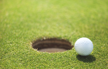 golf ball on lip of cup