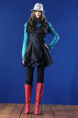 fashion woman in hat posing wooden floor, studio shot