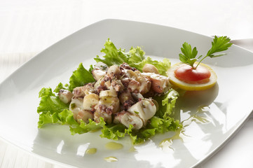 Green salad with small pieces of octopus