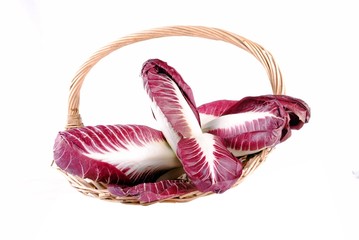 red radicchio salad in a straw basket, isolated on white