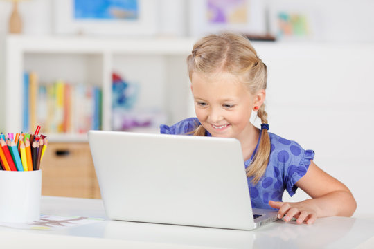 mädchen mit laptop im kinderzimmer