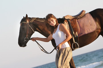 young happy woman with horse on sea background