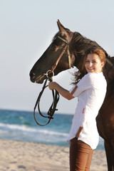 young happy woman with horse on sea background