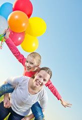 Fototapeta na wymiar Two girls playing outside with balloons
