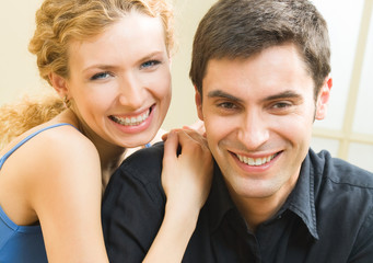 Cheerful smiling young couple, indoors