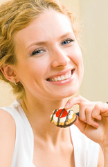 Cheerful woman eating cookies