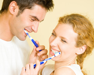Cheerful young couple cleaning teeth together - Powered by Adobe