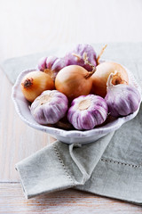 Garlic bulbs and onions in a bowl