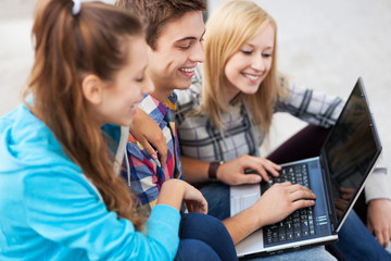 Young people looking at laptop together