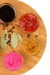 various sauces on chopping board isolated on white