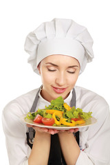 Pretty cook chief holding salad, isolated on white background