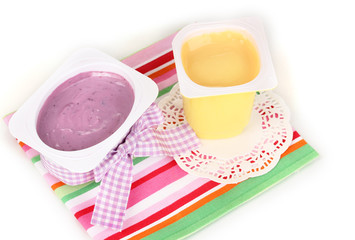 Yogurts with banana and blueberries close-up isolated on white