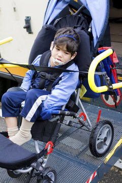 Disabled little boy on school bus wheelchair lift