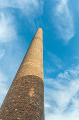 Old factory chimney reaching for the blue sky