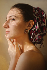 портрет молодой девушки с платком на голове смотрящей вбок