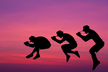 Silhouette photographer jumped in the sky.