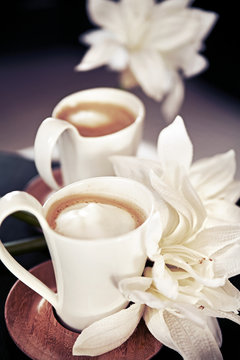 cups of milk coffee with flowers