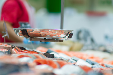 Fresh fishes lie on table with ice in supermarket