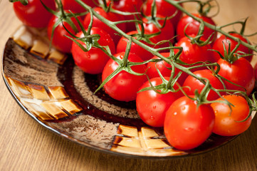 branch of red tomatoes on a plate