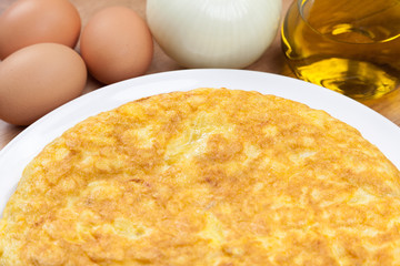 Spanish tortilla (omelette) in a plate, and some ingredients