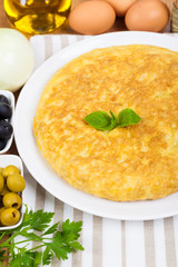 Spanish tortilla (omelette) in a plate, and some ingredients